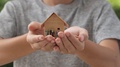 Slose Up Slow Motion At Mini House Model With Family In Little Boy Hands