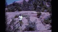 Arizona Usa-1968: Woman Wearing White Shirt Walks On Rock Path Points Back At