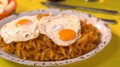 Pasta Pane With Two Fried Eggs On Top And Green Tablecloth