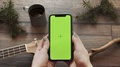 Woman Holding In Hands A Phone Touches A Green Screen