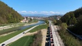 Drone Follows A Goods Train That Runs Along A River Heading To A City.