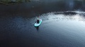 Aerial View Of Young Woman On Paddle Board In Alpine Lake Under Mountain