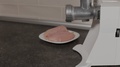 A Man Moves A Plate For Minced Meat To A Meat Grinder.