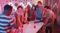 Young Man Drinking From Red Cup While Losing Beer Pong At Party With Friends