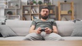 A Man Is Bored At Home On The Sofa And Plays Video Games