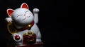 Closeup Shoot Of White And Red Shiny Chinese Lucky Cat Waving A Paw With