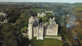 Aerial Drone View Of Old Castle On A Hill Surrounded By Forests On The
