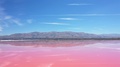 Panoramic View Of Pink Salt Flats And Mountain Range On Sunny Blue Day