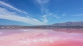 Colorful Pink Salt Flats Near Mountain Range On Bright Sunny Blue Day,
