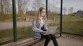 Woman In Face Mask Works On Laptop At Bus Stop