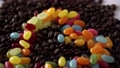 Colorful Jelly Beans In Shape Of Heart Between Golden Brown Coffee Beans
