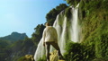 Rear View Of Standing Tourist Looking At View Of Ban Gioc Waterfall In Vietnam
