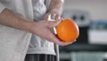 Disinfecting Of An Orange Fruit With Antibacterial Wipe In The Kitchen