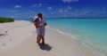 Slow Motion View Of A Caucasian Couple Dancing On The Pristine White Beach Of A