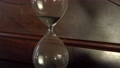 Black Magnetic Sand Falls Through The Small Opening Of A Vintage Hourglass