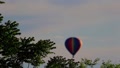 Out Of Focus Rainbow Hot Air Balloon Descends In Background At Dawn