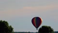 Rainbow Colored Hot Air Balloon Ascends Slowly To Right Firing Propane
