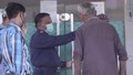 Security Guard Checks The Temperature Of Old Man With The Infrared Thermometer
