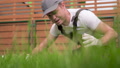 Crazy Man Cutting Grass With Scissors