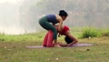 Yoga Instructor Assists Adjusts Student In Yoga Practice.