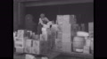 1930s San Francisco: Warehouse, Men Unload Boxes From Tall Pile. Train Rolls