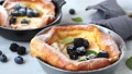 Dutch Baby Pancake With Berries And Lemon In Cast Iron Frying Pan