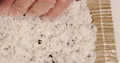 Hands With Disposable Plastic Gloves Flattening Japanese Rice On The Nori