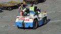 Slow Motion: Asian Airport Workers Sitting On Airport Car On Runway In Sunshine