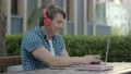 Man In The Garden Listening To Music On Headphones And Laughing Sincerely.