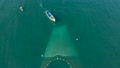 Aerial Top Down View Of Fisherman Boat With The Fishnet Being Laid Over