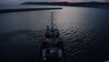 Tugboat Pulling Cruise To Port At Sunset. Handheld, High Angle