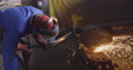 Factory Worker Using A Grinder To Grind Off Rough Edges On A Steel Part