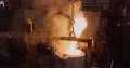 Close-Up View Of A Factory Worker Pouring Molten Metal Out A Smelting Furnace