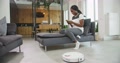 Smiling Young African American Lady House Owner Is Sitting On Sofa In Living