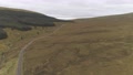 Aerial Footage Over Two White Cars Travelling On A Long And Winding Road.