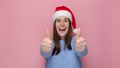 Happy Delighted Young Woman In Christmas Hat Doing Winner Gesture Say Yes