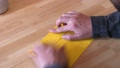 Timelapse Of Hands Making Origami On Table With Yellow Paper, Static, High