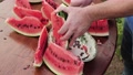 Male Hands Carefully Cut The Leftover Watermelon Into Slices With A Knife.