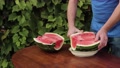 The Man Cuts Off A Slice Of Watermelon With A Knife, Puts It Next To It.