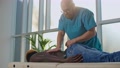 Physiotherapist Conducts Massage Therapy, To African Young Man To Restore Muscle