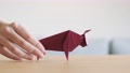 A Hand Moving A Red Origami Ox On Table As Symbol For A Happy Chinese New Year.