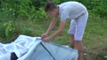 Father And Son Work Together To Setting Up Camping Tent In Green Forest.