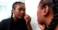 Young Black Woman Applying Make-Up In Front Of Mirror. Casual African Mixed R