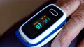 Digital Pulse Oximeter On Old Person's Finger, Monitor Showing Oxygen Rate Index