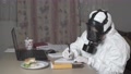 Fat Woman In Gas Mask And Protective Suit Working At Her Desk In Her Home Office
