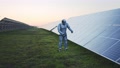 Solar Farm. Funny Scene Of Comical Robot Prototype Dancing Near Solar Panels On