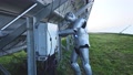 Cybernetic Silver Robot Connecting Wires Of Solar Batteries Working Alone At