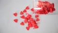 Red Heart Shaped Candy Pouring From Hampagne Glass On The Table. Valentine's Day