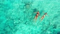 Top View Of Two Girls In Fabulous Bikinis Floating Peacefully On The Gentle Tur