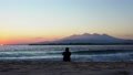 Wide Angle Of A Woman Sitting On The Sand And Enjoying The Calming View Of The